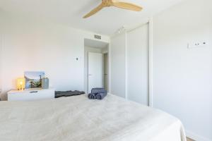 a white bedroom with a large bed and a ceiling fan at A&N Casa Laguna in Torre del Mar