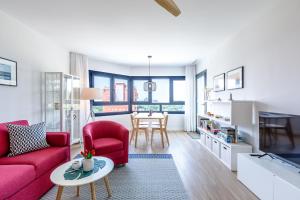 a living room with a red couch and a table at A&N Casa Laguna in Torre del Mar