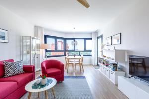 a living room with a red couch and a table at A&N Sea View Apartment with Pool & Parking Torre del Mar in Torre del Mar