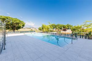 a swimming pool with a metal fence and trees at A&N Sea View Apartment with Pool & Parking Torre del Mar in Torre del Mar
