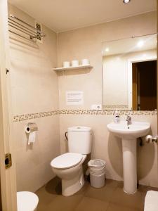 a bathroom with a toilet and a sink at Pensión Pamplonabeds in Pamplona