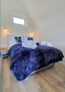 a bedroom with a large bed with towels on it at Bombie Glamping Pod in Grantown on Spey