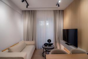 a living room with a couch and a tv at Contessa Bianca Luxury Suites in Corfu Town