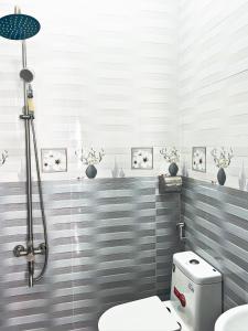 een badkamer met een douche en een toilet. bij Pema House Hotel in Da Thanh