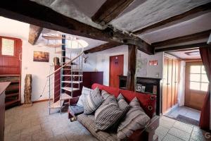 ein Wohnzimmer mit einem roten Sofa und einer Treppe in der Unterkunft Le Forgite - Gîte de charme in Matagne-la-Petite