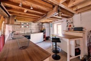eine Küche mit Holzdecken und einem Holztisch in der Unterkunft Le Forgite - Gîte de charme in Matagne-la-Petite