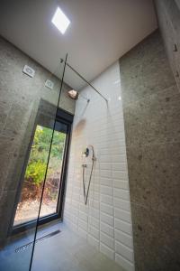 a bathroom with a shower with a glass door at KOKO VILLAGE in Podgorica