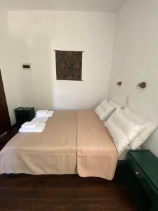 um quarto com uma cama com lençóis brancos e almofadas em Belessi's Mansion em Yéfira
