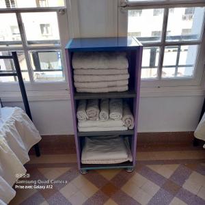 uma prateleira roxa com toalhas num quarto com janelas em Chez abdessalam em Fez