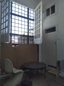 um quarto com uma mesa e cadeiras e uma janela em Chez abdessalam em Fez