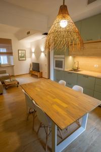 una sala da pranzo con tavolo in legno e una cucina di Appartamenti le Scalette G e D a Osimo