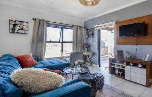 a living room with a blue couch and a tv at Vacation at the Blyde Riverwalk Estate in Pretoria