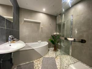 a bathroom with a tub and a sink and a shower at LIVING'Melun, la campagne à Melun ! in Melun
