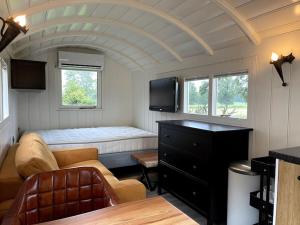 een woonkamer met een bank en een bed bij Natuurhuisje Markelo, zeer compleet, met veel luxe in Markelo