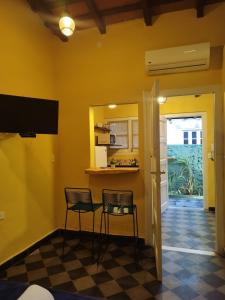 a room with two chairs and a kitchen with yellow walls at Taguato Recoleta in Asuncion