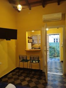 a room with two chairs and a kitchen with yellow walls at Taguato Recoleta in Asunción
