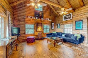 ein Wohnzimmer mit einem Sofa und einem Tisch in einer Blockhütte in der Unterkunft Cabin in the Vermont Woods in Hyde Park