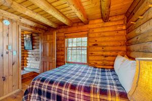 sypialnia z łóżkiem w drewnianym domku w obiekcie Cabin in the Vermont Woods w mieście Hyde Park
