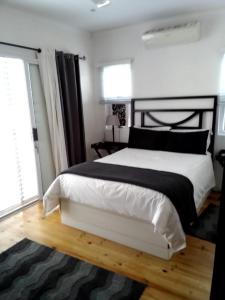 a bedroom with a large white bed and a window at ZEN Tree bed & breakfast in Paarl +1 photo