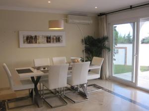 ein Esszimmer mit einem Tisch und weißen Stühlen in der Unterkunft Private Villa, Heated Pool Puerto Banus Marbella in Marbella