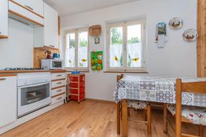 a kitchen with a table and a stove top oven at Villa Elisena in Falcade +21 photos