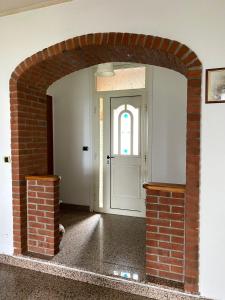 einen Backsteinbogen, der zu einer weißen Tür in einem Zimmer führt in der Unterkunft Villa Belvedere in Susa