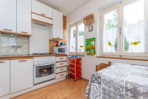 a kitchen with white cabinets and a table at Villa Elisena in Falcade
