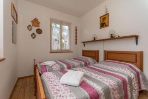 three beds in a room with white walls and a window at Villa Elisena in Falcade