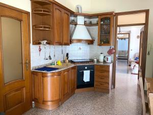 een keuken met houten kasten en een wastafel bij Villa Belvedere in Susa