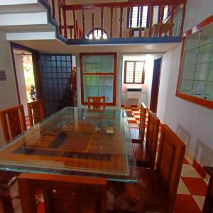 a dining room with a glass table and chairs at Wayanad Empire Villa in Kalpetta
