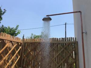 a water fountain spraying out of a wooden fence at UTOPIA RESIDENCES Kazantzakis House in Petrokefálion