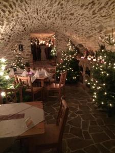 un restaurante con árboles de Navidad y mesas en una habitación en Goldsberghof, en Pöllauberg