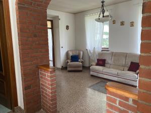 a living room with a couch and a brick wall at Villa Belvedere in Susa