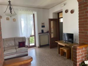 een woonkamer met een bank en een televisie bij Villa Belvedere in Susa