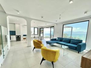 a living room with a blue couch and yellow chairs at Villa Balchik in Balchik