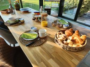 un tavolo con pane e tazze e un cesto di cibo di Casa des Augas a Ousse