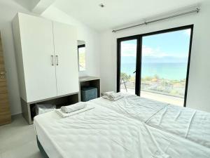 a bedroom with a large white bed and a large window at Villa Balchik in Balchik +37 photos