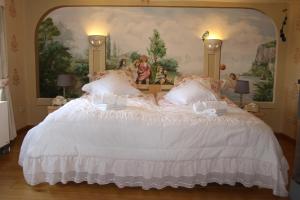 a bedroom with a large white bed with a painting at Pension Rhöner Kräuterwerk 