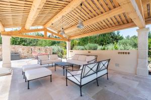 une terrasse avec des chaises et une pergola en bois. dans l'établissement Mas de Lure, à Salon-de-Provence