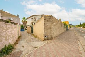 una calle vacía junto a una pared de ladrillo en Casa Murru, en SantʼAntìoco
