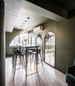 a dining room with a table and stools at Cher Hostel Bangkok in Bangkok