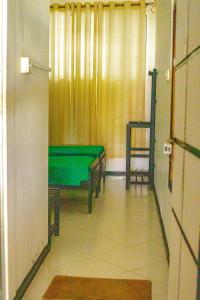 ハンバントタにあるHotel Sanasumaの緑のテーブルと椅子が備わる客室です。