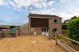 a brick house with a fence in front of it at Bellamy Road - 3 Bedroom home in Oundle