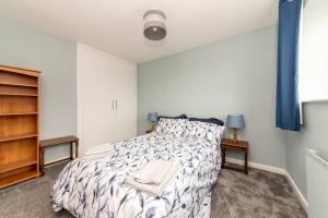 a bedroom with a bed with a white comforter at Bellamy Road - 3 Bedroom home in Oundle