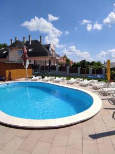 a large swimming pool with chairs and a house at Apartment Gyenesdias 17 in Gyenesdiás