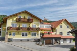 un edificio amarillo con balcones y flores. en Goldsberghof, en Pöllauberg