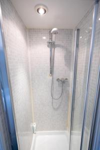 a shower in a bathroom with a glass shower stall at Bell Hotel by Greene King Inns in Tewkesbury