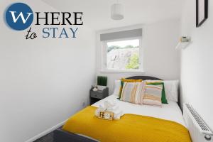 a bedroom with a yellow bed and a sign that reads where to stay at Lovely 2 bedroom house Edinburgh in Edinburgh