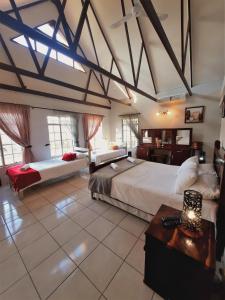 1 dormitorio grande con 2 camas y mesa en Highlands Creek Self Catering Accommodation en Nelspruit