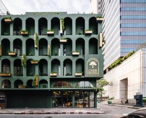 a green building with a sign on the side of it at Cher Hostel Bangkok in Bangkok